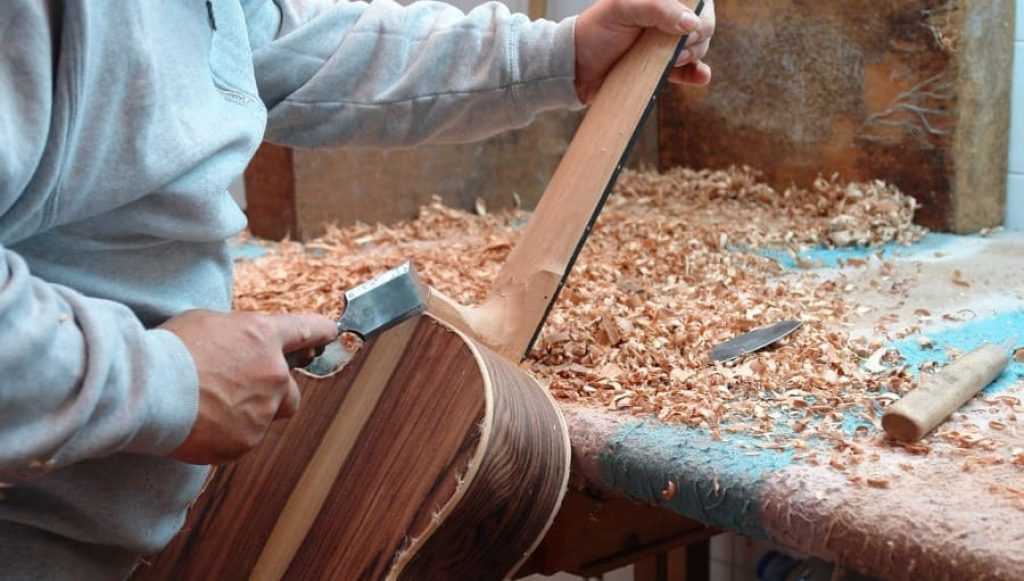 Vue d'un luthier travaillant le bois massif
